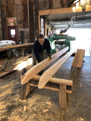 Volunteer Bill Salancy sands the replica sledge's two 16-foot long runners in the Henry B. duPont Preservation Shipyard. Photo by Elissa Bass/Mystic Seaport Museum